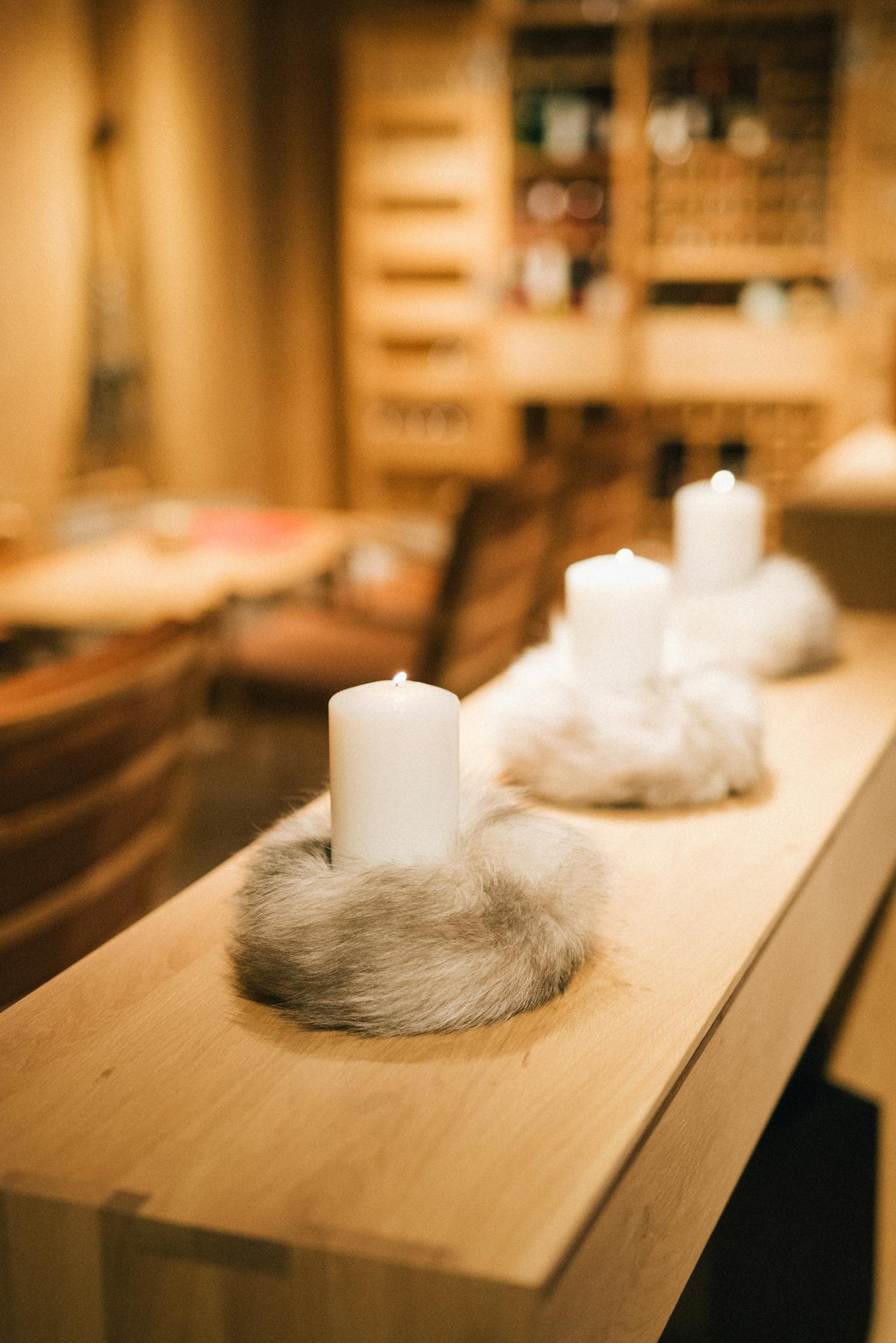 Warm, inviting scene with lit candles on a wooden table, ideal for cozy interiors.